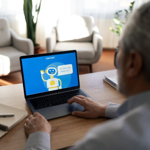 Senior man interacting with an ai chatbot on a laptop computer (iStock)